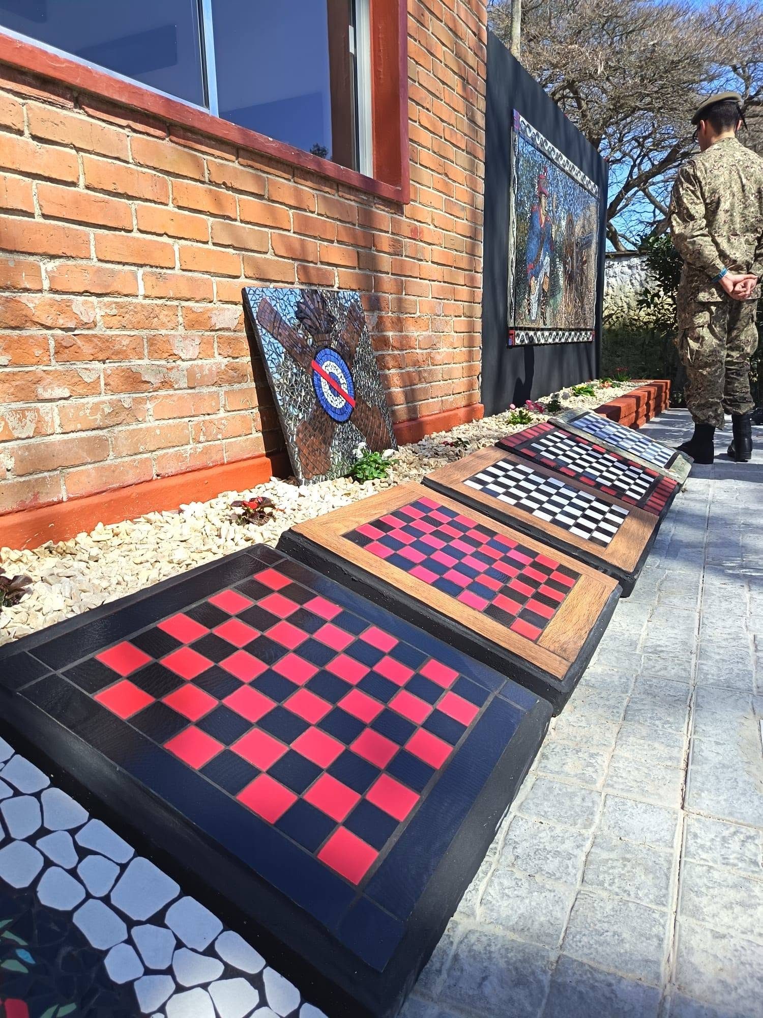 Los tableros de damas y ajedrez en mosaico, con el escudo y el mural al fondo, el día de la inauguración