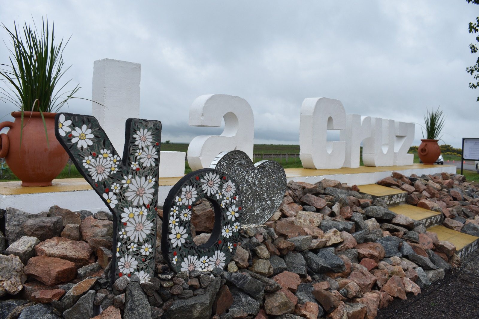 Detalle de las letras "Yo" en mosaico de margaritas cerámicas junto al corazón de fragmentos de espejo
