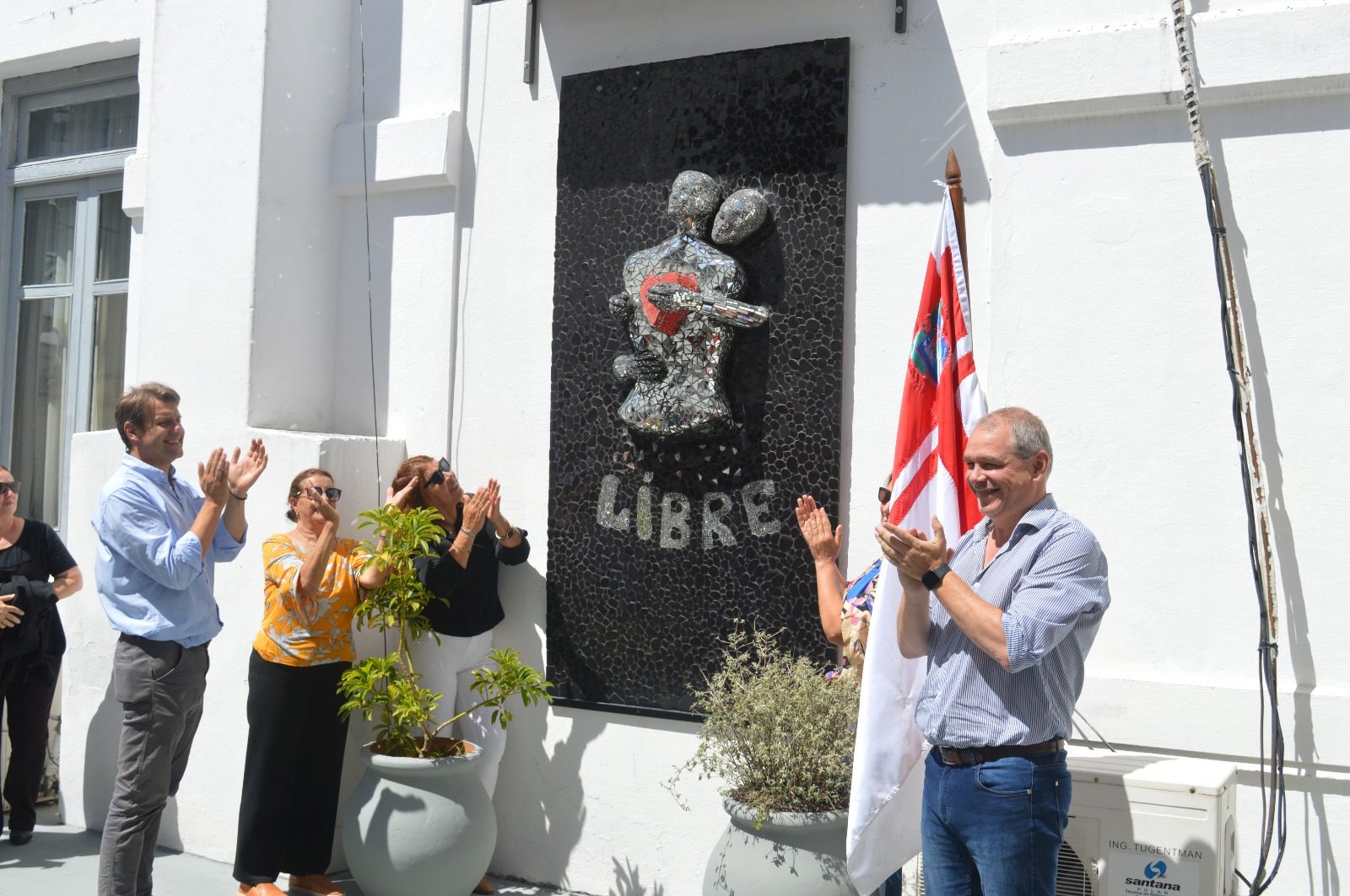Mural Libre en el patio del Edificio Comunal de Florida: la palabra LIBRE en mosaico negro y una figura de espejos, el día de la inauguración.