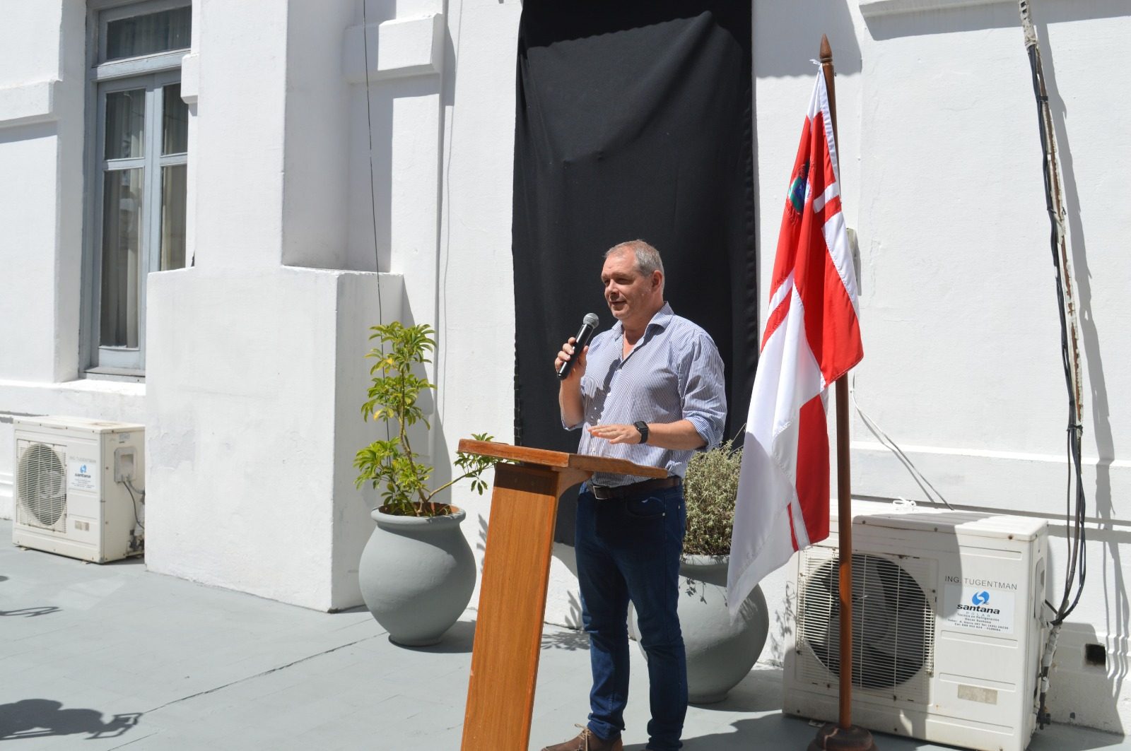 El intendente de Florida, Ing. Guillermo López, hablando al micrófono en el atril, con la bandera de Florida detrás
